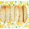 6 pieces of Lemon Poppy Seed Mandel Bread, shaped like biscotti, chewy like a cookie, sprinkled with poppy seeds and placed on a lemon backdrop